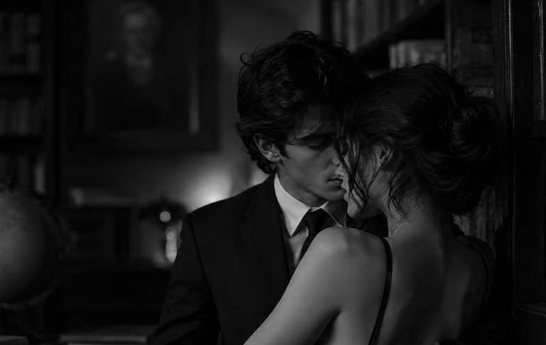 Escena de un libro romantico de dos personas besándose en una librería.