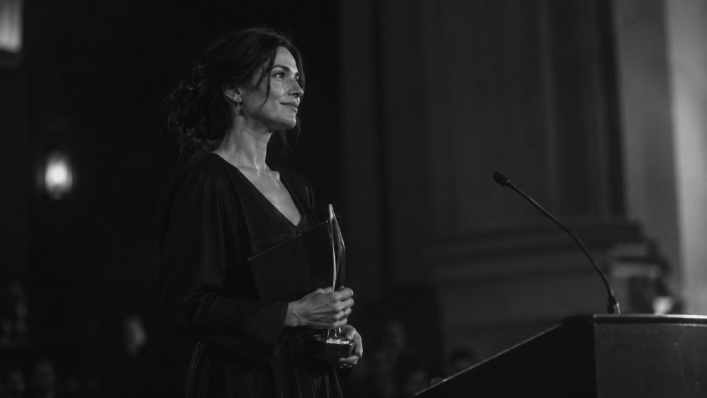 Escritora recibiendo un premio de un certamen literario